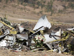 A bouquet of flowers sits in front of a pile of debris at the scene of the Ethiopian Airlines Flight 302 crash.