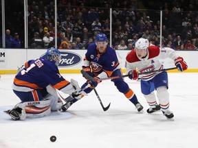Islanders goalie Thomas Greiss and defenceman Adam Pelech moitor Canadiens' Brendan Gallagher during first period Thursday night in Uniondale, N.Y.
