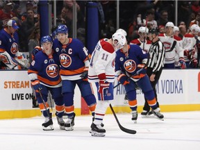 A dejected Brendan Gallagher hangs his head as Anthony Beauvillier, left, and Anders Lee celebrate the Islanders captain's winning goal late in the third period Thursday night in Uniondale, N.Y.