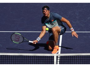 Milos Raonic of Canada plays a forehand volley against Dominic Thiem of Austria during their men's singles semifinal match of the BNP Paribas Open at the Indian Wells Tennis Garden on Saturday, March 16, 2019, in Indian Wells, Calif.
