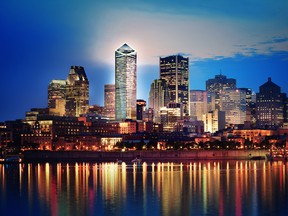 Montreal over river at sunset with city lights and urban buildings