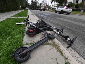 Shared electric scooters lie on a sidewalk in Los Angeles. Montreal is moving to avoid such problems here.