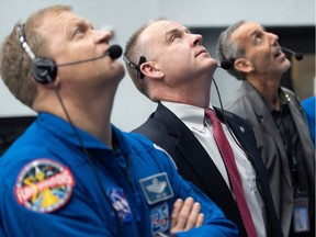 NASA astronaut Doug Hurley (L) and chief of the astronaut office Pat Forrester (2-L) watch the launch of a SpaceX Falcon 9 rocket carrying the company's Crew Dragon spacecraft on the Demo-1 mission from firing room four of the Launch Control Center, March 2, 2019 at the Kennedy Space Center in Florida.