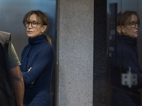 TOPSHOT - Actress Felicity Huffman is seen inside the Edward R. Roybal Federal Building and U.S. Courthouse in Los Angeles, on March 12, 2019. - Two Hollywood actresses including Oscar-nominated "Desperate Housewives" star Felicity Huffman are among 50 people indicted in a nationwide university admissions scam, court records unsealed in Boston on March 12, 2019 showed. The accused, who also include chief executives, allegedly cheated to get their children into elite schools, including Yale, Stanford, Georgetown and the University of Southern California, federal prosecutors said.Huffman, 56, and Lori Loughlin, 54, who starred in "Full House," are charged with conspiracy to commit mail fraud and honest services mail fraud. A federal judge set bond at $250,000 for Felicity Huffman after she was charged in a massive college admissions cheating scandal.