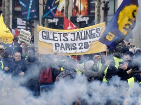 Yellow Vest protesters wave French regional flags on the Champs-Elysees in Paris on March 16, 2019, during the 18th consecutive Saturday of demonstrations called by the 'Yellow Vest' (gilets jaunes) movement.