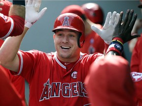 FILE - In this Sept. 10, 2017, file photo, Los Angeles Angels' Mike Trout is greeted in the dugout after hitting a solo home run in the first inning of a baseball game against the Seattle Mariners in Seattle. A person familiar with the negotiations tells The Associated Press Tuesday, March 19, 2019, that Trout and the Angels are close to finalizing a record $432 million, 12-year contract that would shatter the record for the largest deal in North American sports history.