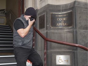 Workplace bullying claimant David Hingst covers his face as he leaves the Court of Appeal in Melbourne, Australia Friday, March 29, 2019.