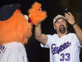 Former Montreal Expos Larry Walker shoots a selfie with mascot Youppi as members of the 1994 team are introduced prior to a pre-season game with the Toronto Blue jays facing the New York Mets Saturday, March 29, 2014 in Montreal.
