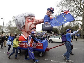 Demonstrators pull a cart with a doll resembling British Prime Minister Theresa May during a Peoples Vote anti-Brexit march in London, Saturday, March 23, 2019. The march, organized by the People's Vote campaign is calling for a final vote on any proposed Brexit deal. This week the EU has granted Britain's Prime Minister Theresa May a delay to the Brexit process.