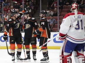 Anaheim Ducks' Troy Terry, centre, is congratulated by Cam Fowler, left, and Adam Henrique after he scored a goal against Canadiens goaltender Carey Price on Friday, March 8, 2019, in Anaheim, Calif.