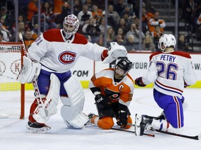 Philadelphia Flyers' Claude Giroux gets a shove from Montreal Canadiens' Carey Price, left, after a collision with Jeff Petry during the second period on March 19, 2019, in Philadelphia.