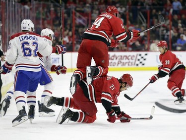 Carolina Hurricanes' Justin Williams (14) jumps over teammate Nino Niederreiter (21), of the Czech Republic, while Montreal Canadiens' Artturi Lehkonen (62), of Finland, chases the puck during the first period of an NHL hockey game in Raleigh, N.C., Sunday, March 24, 2019.
