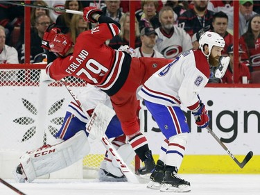 Carolina Hurricanes' Micheal Ferland (79) trips in front of Montreal Canadiens goalie Carey Price as Canadiens' Jordie Benn (8) skates past during the first period of an NHL hockey game in Raleigh, N.C., Sunday, March 24, 2019.