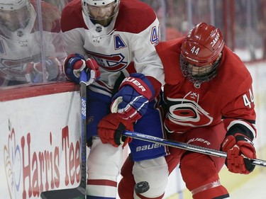 Montreal Canadiens' Paul Byron (41) and Carolina Hurricanes' Calvin de Haan (44) chase the puck during the first period of an NHL hockey game in Raleigh, N.C., Sunday, March 24, 2019.