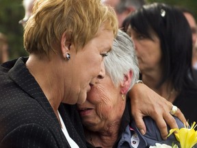 Quebec Premier-elect Pauline Marois, left, helps Ginette Jean, mother of Denis Blanchette, during funeral services Monday, Sept. 10, 2012 in Montreal.