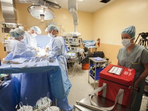 An operating room nurse carries the donor kidney inside an organ box during kidney transplant surgery. "A significant gap exists between the number of people fortunate enough to receive an organ and those still waiting on the list," Alexandra Glezos writes.