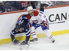 Jets' Andrew Copp gets checked by Canadiens' Victor Mete in Winnipeg on Saturday, March 28, 2019.