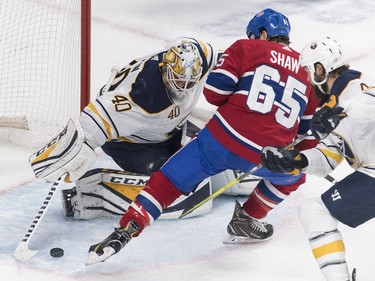 Montreal Canadiens' Andrew Shaw (65) moves in on Buffalo Sabres goaltender Carter Hutton as Sabres' Zach Bogosian defends during first period NHL hockey action in Montreal, Saturday, March 23, 2019.
