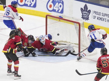 Les Canadiennes de Montreal's Jill Saulnier (right) slips the puck past Calgary Inferno's goaltender Alex Rigsby before the goal is disallowed for goaltender interference by Montreal's Hilary Knight (centre) during third period action in the 2019 Clarkson Cup game in Toronto, on Sunday, March 24 , 2019.