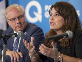 PQ MNA Veronique Hivon, right, speaks to the press as Parti Quebecois leader Jean-Francois Lisee looks on at a press conference in Montreal Thursday, September 13, 2018.