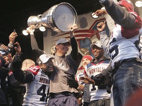 Montreal Alouettes head coach Marc Trestman hoists the Grey Cup with his players at the Quartier des Spectacles following the team’s parade on Dec. 1, 2010.