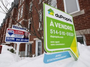 For sale signs are seen in front of a Montreal condominium, Tuesday, March 17, 2015. Home sales ramped up in Montreal last month, marking four years of continuous growth.