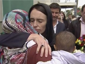 In this image made from video, New Zealand's Prime Minister Jacinda Ardern, center, hugs and consoles a woman as she visited Kilbirnie Mosque to lay flowers among tributes to Christchurch attack victims, in Wellington, Sunday, March 17, 2019. (TVNZ via AP) ORG XMIT: TKSK811