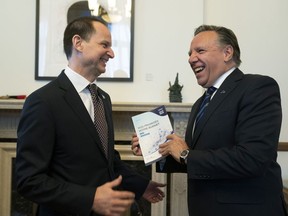 Quebec Premier François Legault receives a copy of the budget speech from Quebec Finance Minister Eric Girard, left, Thursday, March 21, 2019 at the premier's office in Quebec City. Girard will table his first budget since the election of a CAQ government.