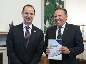 Quebec Premier Francois Legault receives a copy of the budget speech from Quebec Finance Minister Eric Girard, left, Thursday, March 21, 2019 at the premier's office in Quebec City. Girard will table his first budget since the election of a CAQ government.