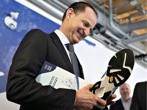 Finance Minister Eric Girard checks his new Quebec-made running shoes he plans to wear for his budget speech on Thursday.