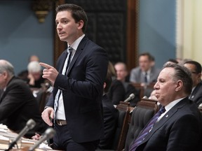 Standing beside Quebec Premier François Legault, Immigration Minister Simon Jolin-Barrette responds during question period, February 26, 2019 at the legislature in Quebec City.