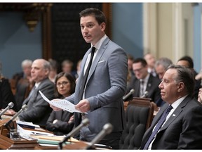 Quebec Minister of Immigration, Diversity and Inclusiveness Simon Jolin-Barrette tables Bill 21 on laicity of the state, Thursday, March 28, 2019 at the legislature in Quebec City. Quebec Premier Francois Legault, right, looks on.