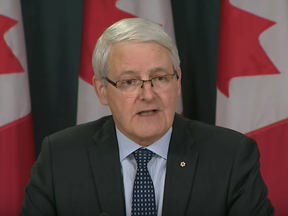 Marc Garneau listened to a protester before turning away.