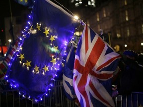 Anti-Brexit, remain in the European Union supporters hold an EU and British union flag outside the Houses of Parliament in London, Wednesday, March 13, 2019.