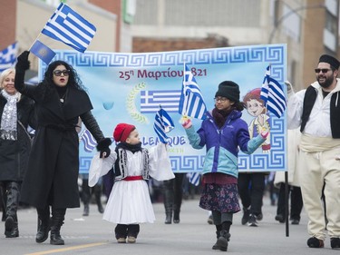 Participants holds flags as they attend the annual Greek Independence Day Parade in Montreal, Sunday, March 24, 2019.