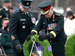 Chief of the Defence Staff Jonathan Vance places his hands on a wreath after laying it down, as Chief Warrant Officer Martin Colbert looks on, during a ceremony honouring Canadians who served and died during Canada's mission in Afghanistan, at the National War Memorial in Ottawa on Sunday, March 31, 2019.