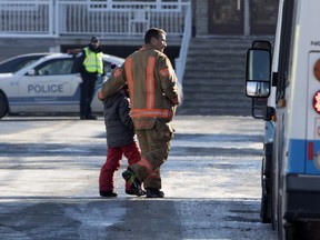 Jan. 14: A firefighter walks a student to a waiting bus after the evacuation of École des Découvreurs.
