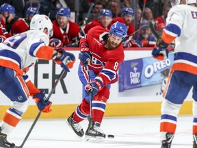 Montreal Canadiens' Jordie Benn fires a shot from the point between New York Islanders' Brock Nelson, left, and Jordan Eberle during third period in Montreal on March 21, 2019.