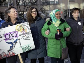 People stand arm in arm during a protest against Bill 21 at Westmount High School in Montreal, April 3, 2019.