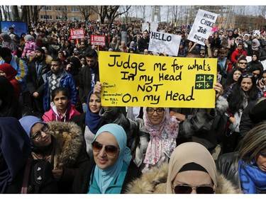 A woman holds a sign in Place Émilie-Gamelin in Montreal on Sunday, April 7, 2019, to denounce the Quebec government's Bill 21.