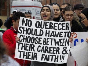 A woman holds a sign in Montreal Sunday, April 7, 2019 at a demonstration to denounce the Quebec government's Bill 21.