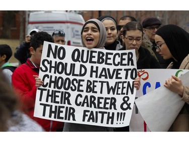 A woman holds a sign in Montreal on Sunday, April 7, 2019, at a demonstration to denounce the Quebec government's Bill 21.