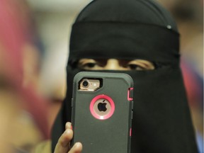 A woman films speakers at Place Émilie-Gamelin in Montreal, April 7, 2019, at a demonstration to denounce the Quebec government's Bill 21.