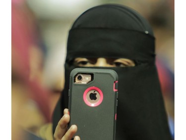 A woman films speakers at Place Émilie-Gamelin in Montreal on Sunday, April 7, 2019, at a demonstration to denounce the Quebec government's Bill 21.