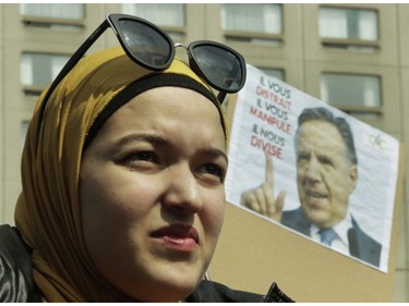 A woman listens to speakers at Place Émilie-Gamelin in Montreal on Sunday, April 7, 2019, at a demonstration to denounce the Quebec government's Bill 21.