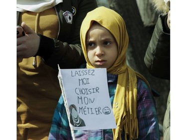 A girl holds a sign in Place Émilie-Gamelin in Montreal on Sunday, April 7, 2019, to denounce the Quebec government's Bill 21.