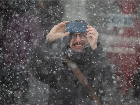Quebec filmmaker Philippe Falardeau takes pictures of a snow squall in Old Montreal on Tuesday.