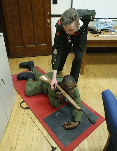 Chief Warrant Officer Jeremie Morgan checks the air rifle of cadet Darrien Crichlow after a marksmanship exercise at the Royal Montreal Regiment in Westmount.