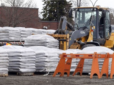 A front-end loader stacks pallets of sandbags from a transport truck at the public works department in the Pierrefonds-Roxboro borough of Montreal April 18, 2019, in preparation for possible flooding.