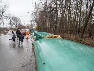 Large water filled barriers sit alongside rue Rive-Boise in Pierrefonds on Friday, April 19, 2019, in preparation of expected flooding along the Riviere des Prairies.